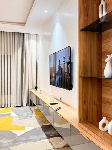 a living room with a television on a wall at Tranquil Ridge BnB in Blantyre