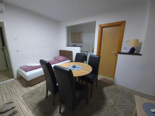 a room with a table and chairs and a bed at Guest House Nana in Mostar