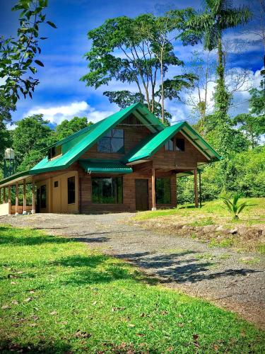 une maison avec un toit vert au-dessus dans l'établissement Cabaña El Tucán, à Guápiles
