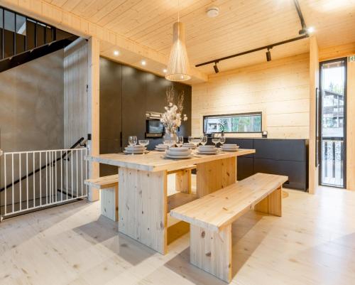 レヴィにあるModern High-Quality 4BR Villa in Levi Next to Ski Slopesの木製のテーブルとベンチのあるオープンキッチン