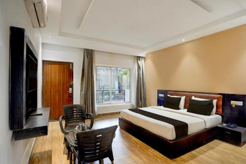 ein Hotelzimmer mit einem Bett und einem Fernseher in der Unterkunft Townhouse Morjim Beach North Goa Formerly Bay Breeze Hotels & Resorts in Chopdem