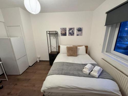 ロンドンにあるRoom in Central London Steps from Eustonのベッドとタオル2枚のある寝室