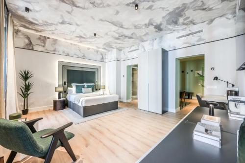 Un dormitorio con una cama y una mesa y sillas. en Suites Madrid Centro, en Madrid