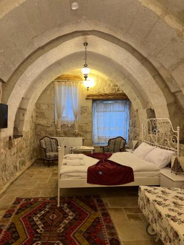 a bedroom with a large bed in a stone wall at Cosy cave suit in Ürgüp
