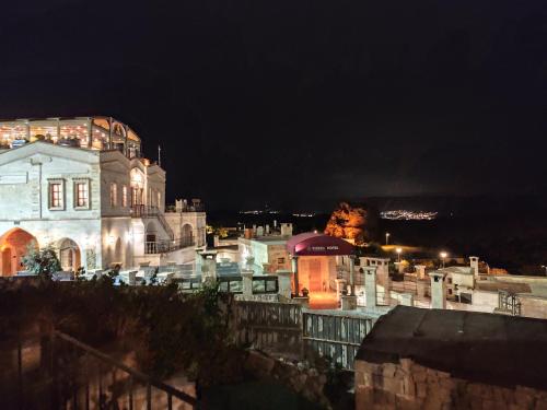 a large building at night with lights on at Cosy cave suit in Urgup
