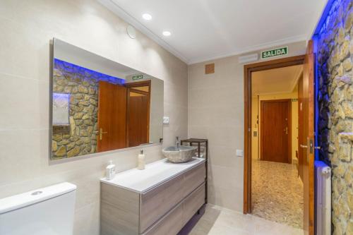a bathroom with a sink and a mirror at Amplia casa para desconectar con vistas al lago in Lerate
