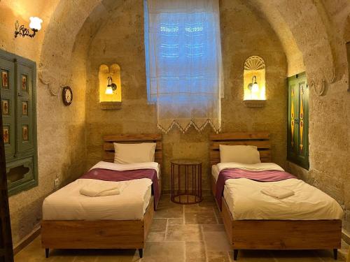 a room with two beds and a window at Cosy cave suit in Urgup