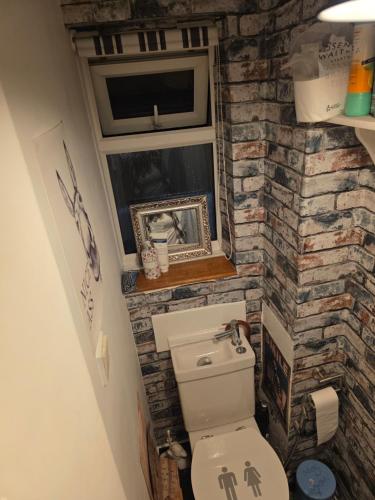 un bagno con un muro in pietra e un water di Spacious rooms Golders Green NW2 a Londra