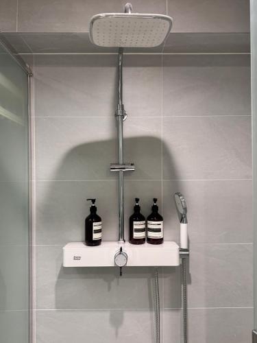 a shelf in a bathroom with three bottles on it at Hotel Myeongdong Station in Seoul