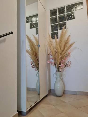 a mirror with two vases with flowers in it at Casa vacanze Castello in Frontone