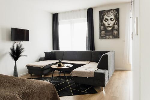 a living room with a couch and a table at Dream Premium Apartman in Mosonmagyaróvár