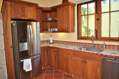 a kitchen with wooden cabinets and a stainless steel refrigerator at Casa Mar de Cortez in Loreto