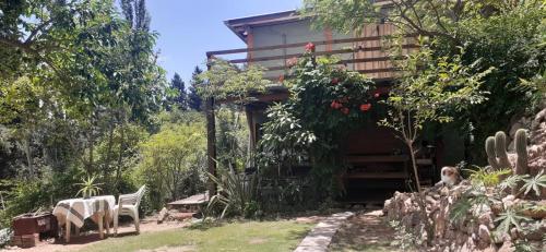 a house with a table and chairs in a garden at Vista Alago in Villa Ciudad Parque