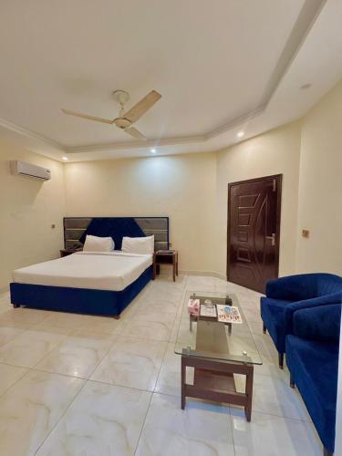 a bedroom with a bed and a couch and a table at Royalton Inn Hotel - Liberty in Lahore