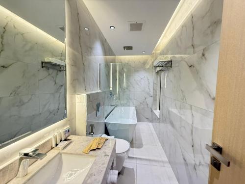 a white bathroom with a sink and a toilet at فندق أثير بارك in Jazan