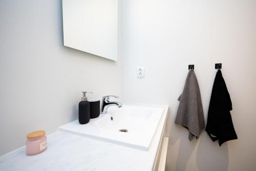 Un baño con un lavabo blanco y un espejo. en Villa Kotikuja, en Rovaniemi