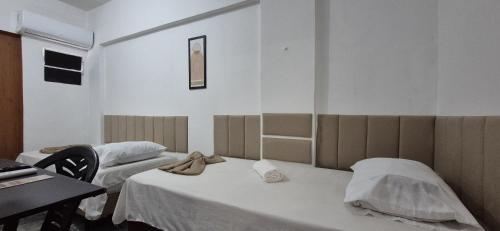 Camera ospedaliera con 2 letti e una scrivania di Pousada Primeiro Sol a João Pessoa