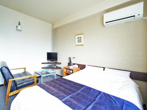 a hotel room with a bed and a chair at Hotel Cerezo in Tokyo