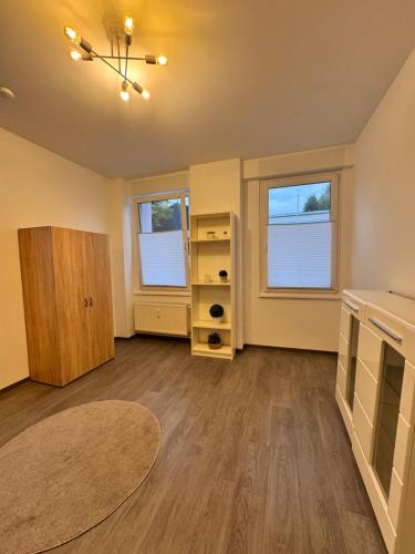 an empty living room with two windows and a rug at FlexHome Gemütliche Ferienwohnung in Lippstadt