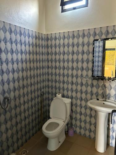 a bathroom with a toilet and a sink at As Résidence in Sindia