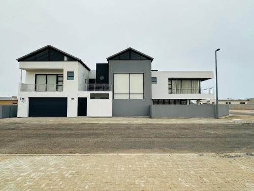 a large white house with a parking lot at Duinen Suites in Walvis Bay
