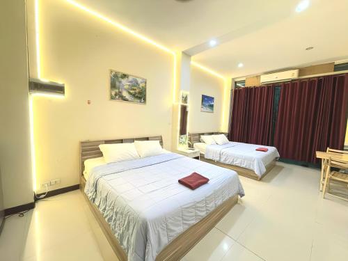 ein Hotelzimmer mit zwei Betten in einem Zimmer in der Unterkunft Asia Mahanakhorn Travel in Bangkok