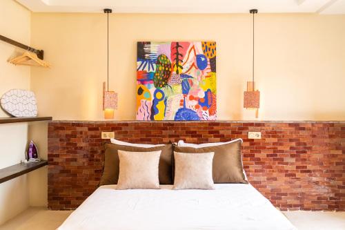 een slaapkamer met een bakstenen muur en een bed met kussens bij Excellent apartment plus hot tub in Marrakesh