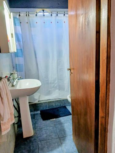 a bathroom with a white sink and a shower at El Descanso in Camet Norte