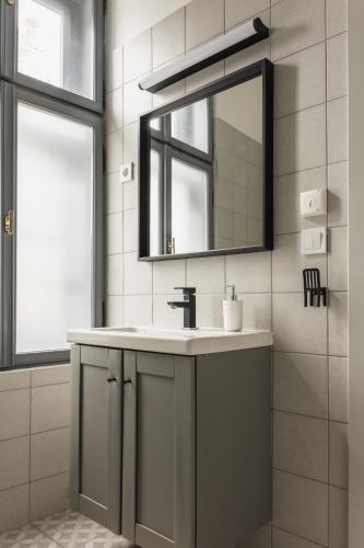 a bathroom with a sink and a mirror at Dream Apartman in Levél