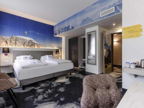 a bedroom with a large bed and a chair at Mercure München am Olympiapark in Munich