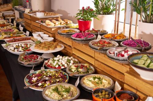 Un buffet con muchos platos de comida en una mesa. en Hotel Cristal Białystok, en Białystok