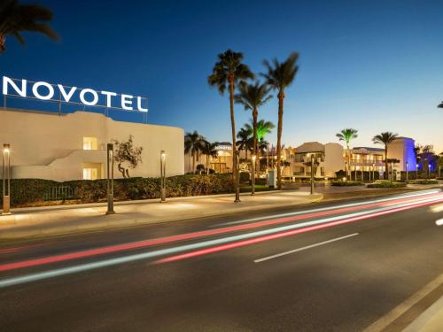 a street in front of a hotel with palm trees at Hotel Novotel Sharm El-Sheikh in Sharm El Sheikh