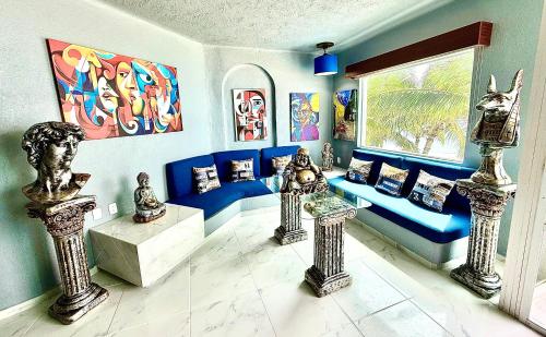 a living room with a couch and paintings on the wall at Espectacular Apto remodelado, de lujo y a pie de Playa con vista al mar in Manzanillo