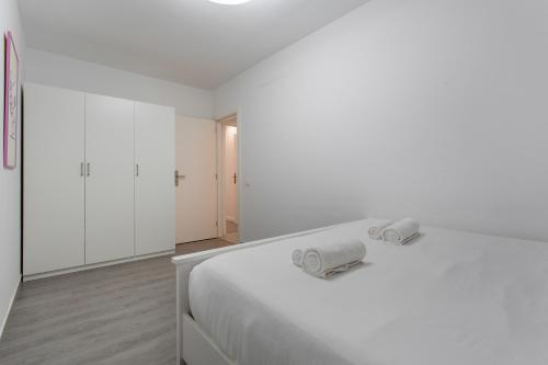 Un dormitorio blanco con una cama blanca con toallas. en Obsidian Aquarela Costa Adeje, en Adeje
