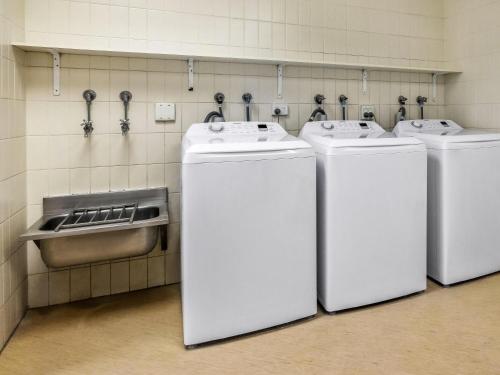 a row of four whitewashers in a bathroom at Novotel Darwin CBD in Darwin