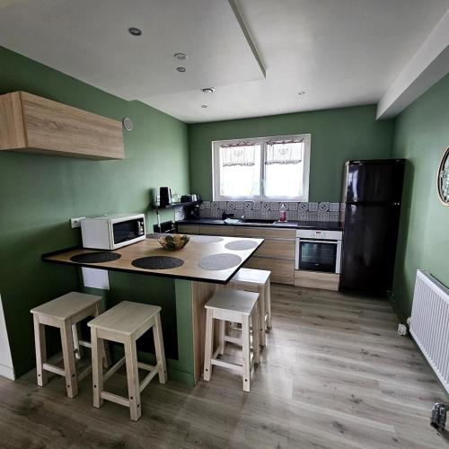 Logement entier في ألونسون: مطبخ بجدران خضراء وطاولة وكراسي
