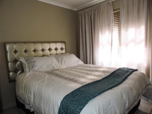 a bedroom with a large white bed with a window at Poplar place Thornton in Cape Town