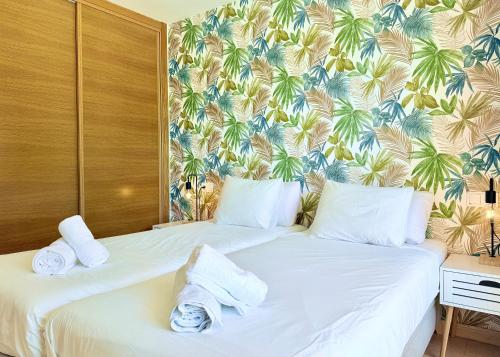 deux lits dans une chambre d'hôtel avec un papier peint tropical dans l'établissement Casa Calma - Mar Menor Golf Resort, à Torre-Pacheco