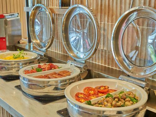 a counter with four trays of different types of food at ibis Perth in Perth