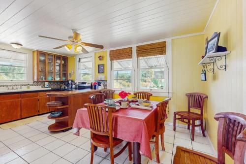 a kitchen with a table and chairs and a ceiling fan at Hamakua Hale Ohana Country Retreat in Papaikou