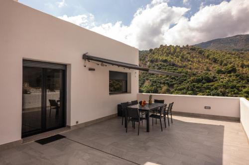 une terrasse avec une table et des chaises sur un balcon dans l'établissement Comeback el Rinconcito de Guajar, à Guájar-Faragüit