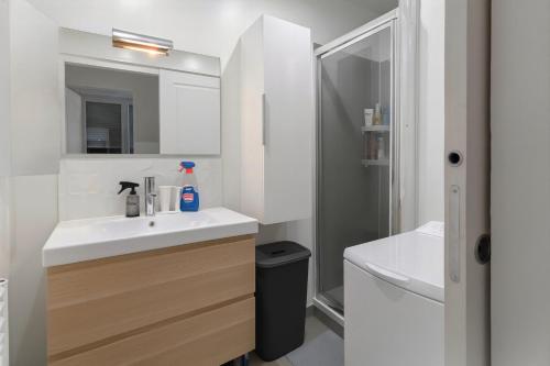 a white bathroom with a sink and a toilet at Élégant Appart Proche De Paris in Nanterre