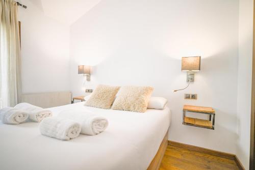 a bedroom with a white bed with towels on it at Acceso Directo a Grandvalira I Ski, Vistas y Relax I Cabirol in Sant Pere