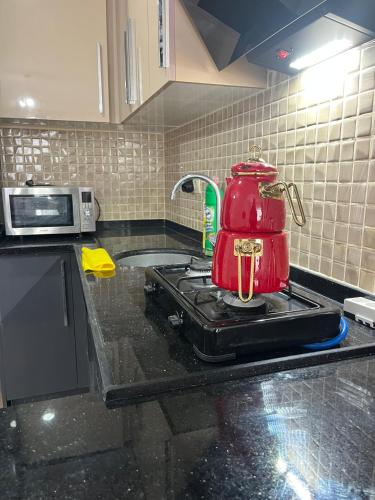 a red tea kettle on a stove in a kitchen at mersin merkezde her yere kolay ulaşım in Mersin