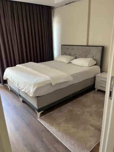 a bedroom with a large bed with white sheets and pillows at mersin merkezde her yere kolay ulaşım in Mersin