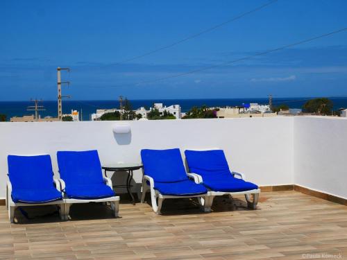 a group of blue chairs and a table on a roof at Dar Iziki Separate Apartment in Sidi Kaouki