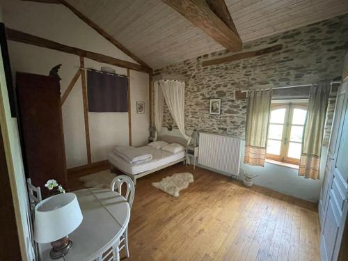 a living room with a bed and a table at Grand gîte pour 18 personnes dans la campagne tarnaise in Andouque