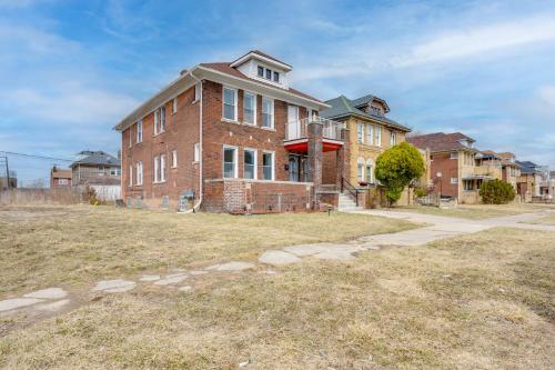an old brick building in a field with houses at Pet-Friendly Detroit Apt Near Motown and DIA in Detroit