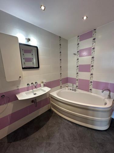 ein Badezimmer mit zwei Waschbecken und einer Badewanne in der Unterkunft Sea view apartment next to Sea garden and beach in Warna