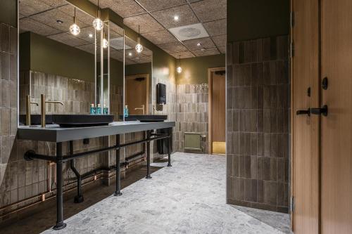 une salle de bain avec deux lavabos et deux miroirs dans l'établissement Best Western Hotell Kramm, à Kramfors